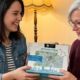Tochter überreicht ihrer Mutter im Wohnzimmer das München-Stadtplan-Puzzle von PuzzleMap